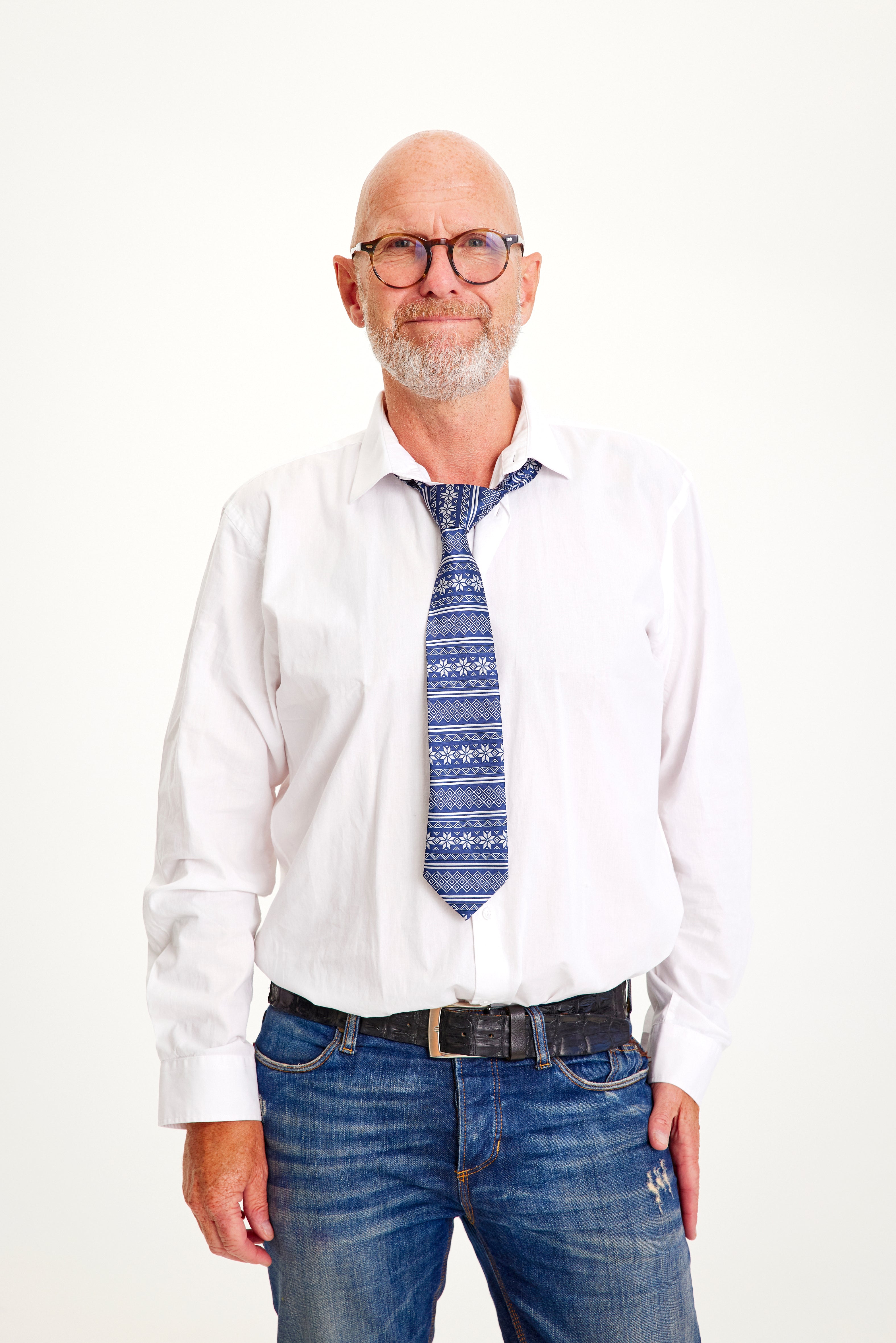 Een lachende man met een wit overhemd en een blauwe stropdas.